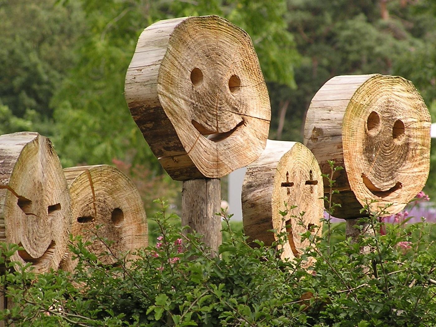 Holzscheiben lachende Gesichter im Garten